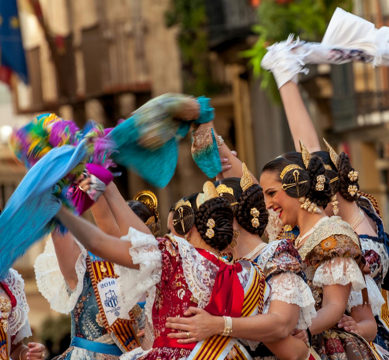 Women in traditional Spanish attire celebrate a cultural festival in Valencia with vibrant dances and festive spirit.