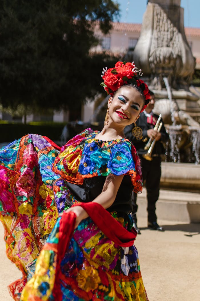 A young Hispanic woman in colorful traditional dress dances joyfully at a Mexican festival.